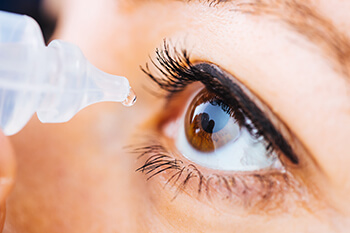 Close up of woman putting in eye drops